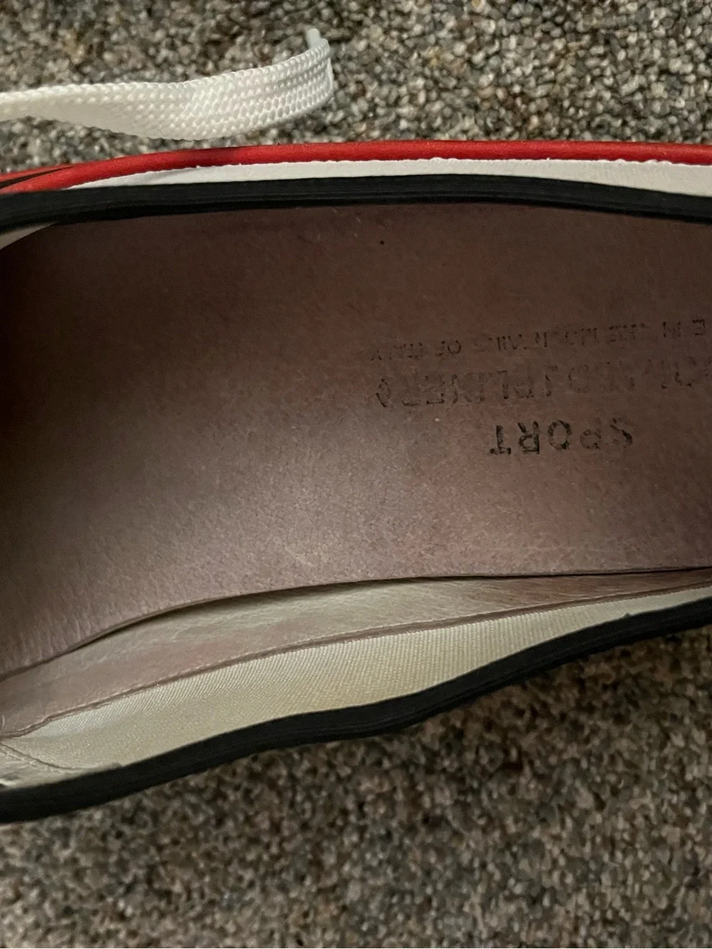 Donald J Pliner white canvas and black leather sneakers with red trim.